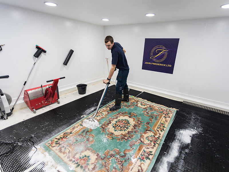 A member of John Fredericks staff cleaning a rug